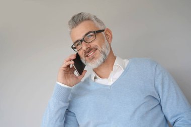 Akıllı telefon kullanan orta yaşlı bir adamın portresi. 