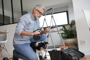 Evdeki adam köpek yavrusuyla tek başına iş yapıyor.