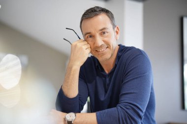 Mavi gömlekli orta yaşlı bir adamın portresi.