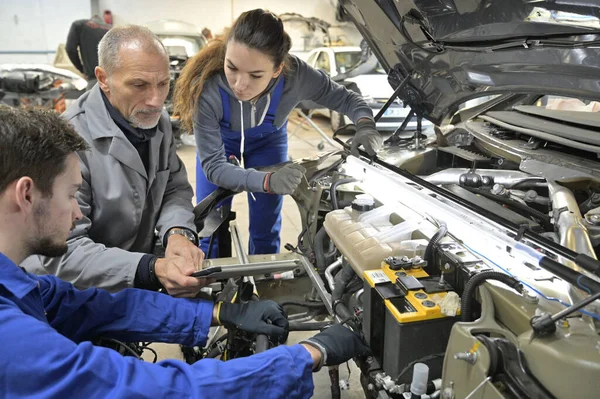 Instructeur Met Stagiairs Die Aan Een Automotor Werken — Stockfoto