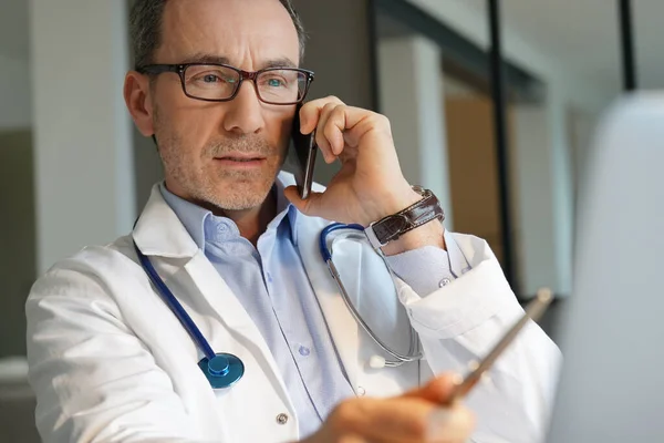 Médico Oficina Trabajando Ordenador Portátil Hablando Por Teléfono —  Fotos de Stock