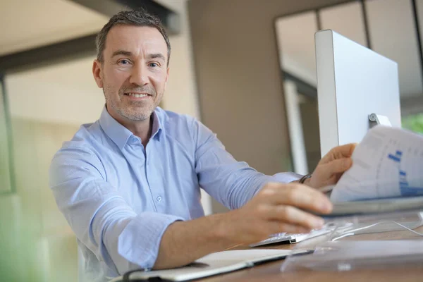 Office デスクトップ コンピューター上で作業中の男 — ストック写真