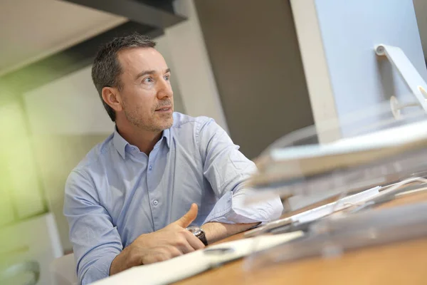 Man in office working on desktop computer