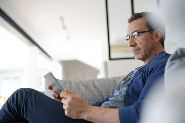 Man Van Middelbare Leeftijd Thuis Zittend Bank Met Tablet — Stockfoto