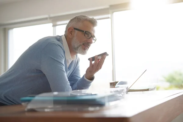 Man Het Kantoor Werken Laptop Computer Met Behulp Van Smartphone — Stockfoto