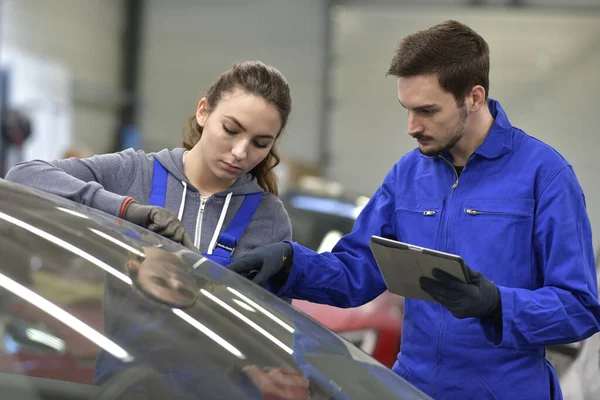 Apprentice in car industry using digital tablet