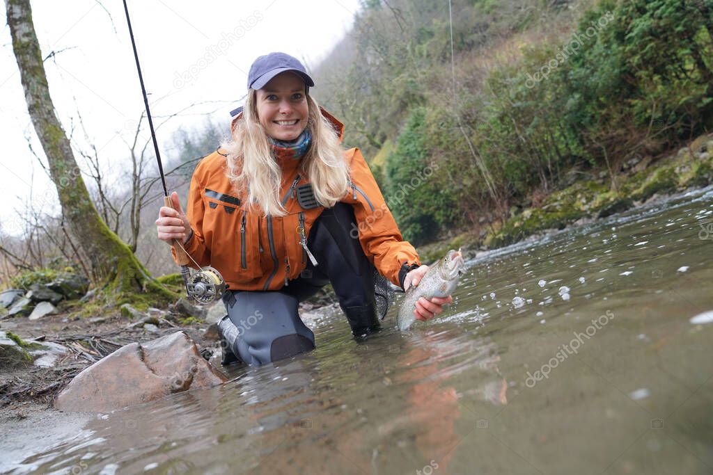 woman fly fishing catching rainbow trout