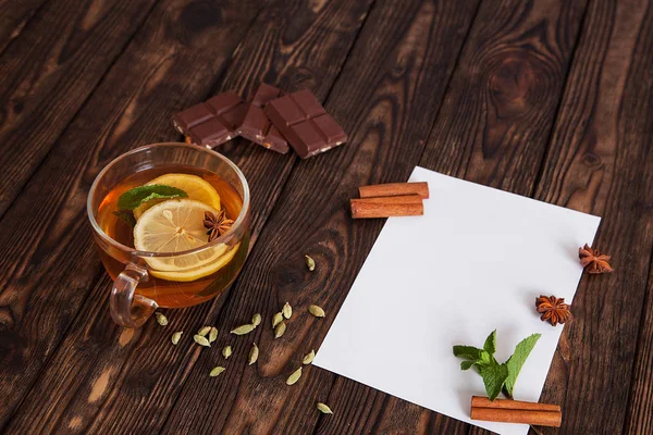 Papier na drewnianym stole z kubkiem herbaty — Zdjęcie stockowe