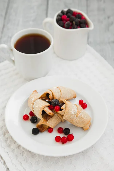 tatlı simit kurabiye ve çilek ile iki beyaz cups bir plaka üzerinde