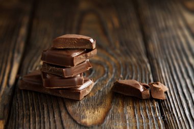 lezzetli koyu çikolata parçaları ahşap bir karanlık eski masa üzerinde bir blok