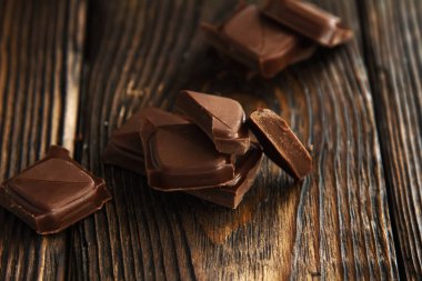 lezzetli koyu çikolata parçaları ahşap bir karanlık eski masa üzerinde bir blok