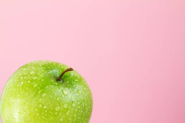 pembe bir arka plan üzerinde yeşil elma parçası