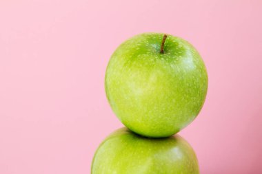 pembe bir arka plan üzerinde yeşil elma parçası