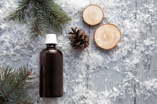 Çam aromalı yağ kozmetik şişe aroma terapisinde kış karlı arka planda doğal olarak elde edilir.