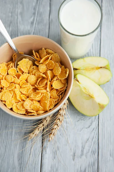 Healthy breakfast with glass of milk, apple and corn flakes — Stock Photo, Image