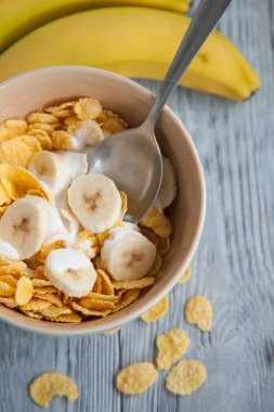 Sağlıklı kahvaltı, bir bardak süt, muz ve mısır gevreği.