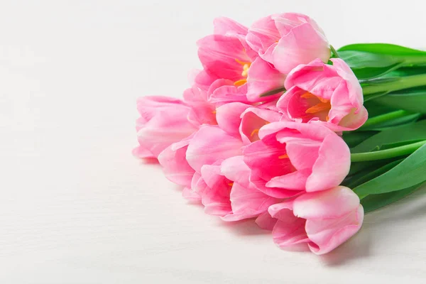 Mooie roze tulpen bloemen op witte houten achtergrond. — Stockfoto