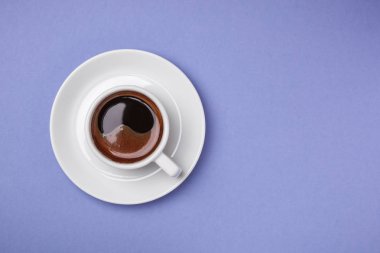 Fincan espresso ile mavi arka plan üzerinde uçan daire.