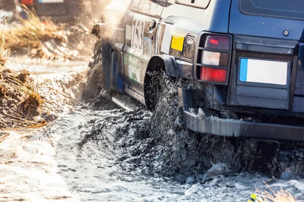Задний вид внедорожного гоночного автомобиля преодолевает водяную яму . — стоковое фото