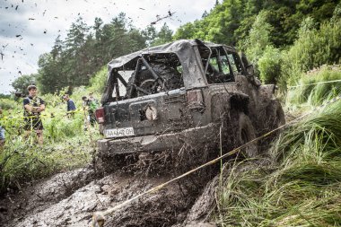Katılımcı Jeep üzerinde derin çamurlu çukur geçer.
