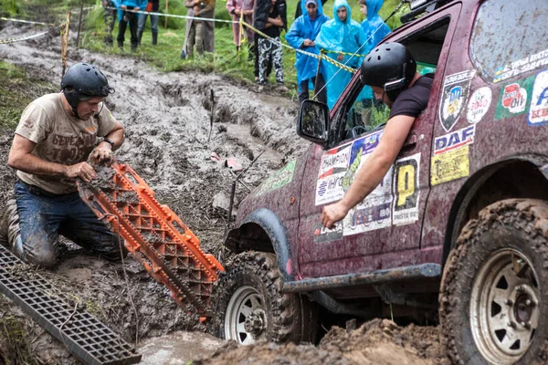 Equipo que utiliza pistas de arena de recuperación para superar un pozo duro . — Foto de Stock