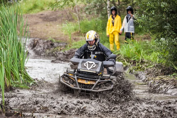 Quad bisiklet üzerinde katılımcı bir derin su çukuru geçer. — Stok fotoğraf