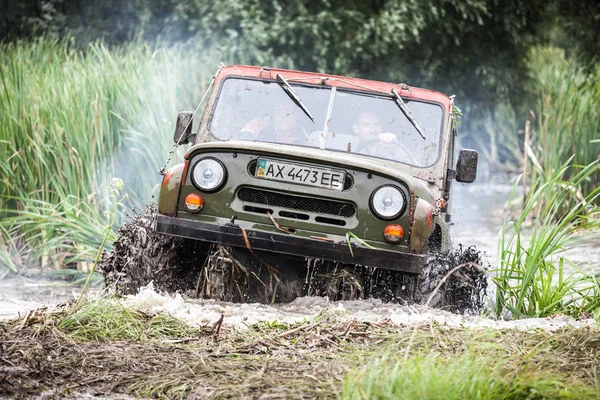 Maßgeschneiderte Offroad-Trophäe uaz 469 verlässt den Sumpf mit hoher Geschwindigkeit. — Stockfoto