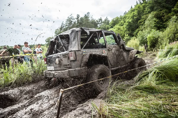 De deelnemer op Jeep gaat een diepe modderige put. — Stockfoto