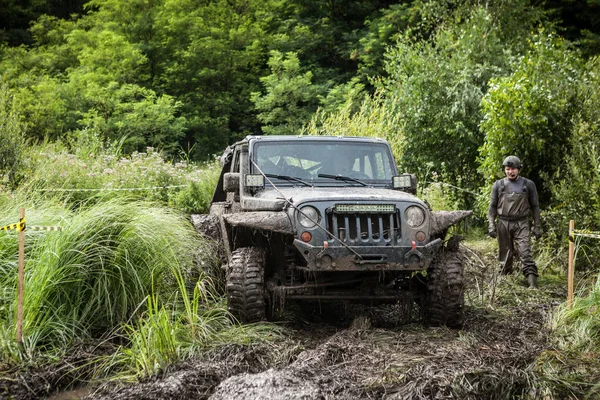 El participante en Jeep pasa un pozo fangoso profundo . — Foto de Stock