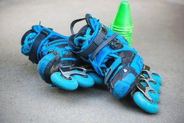 Asfalt üzerinde yalan slalom koniler ile mavi tekerlekli paten.