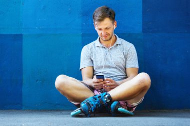 Satır içi paten blu karşı oturma içinde mutlu yakışıklı genç roller