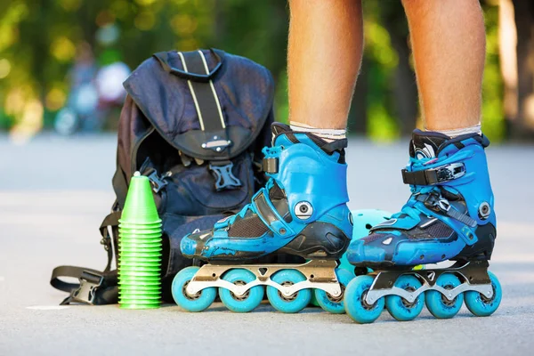 Foto de primer plano de las piernas en patines en línea azules de pie . —  Fotos de Stock