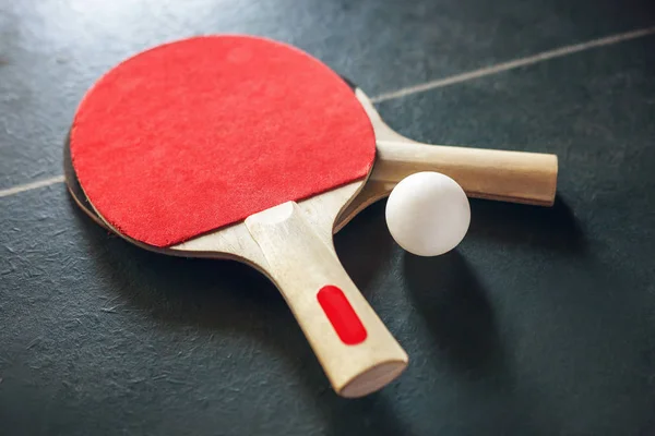 Vintage table tennis rackets and ball on old table.
