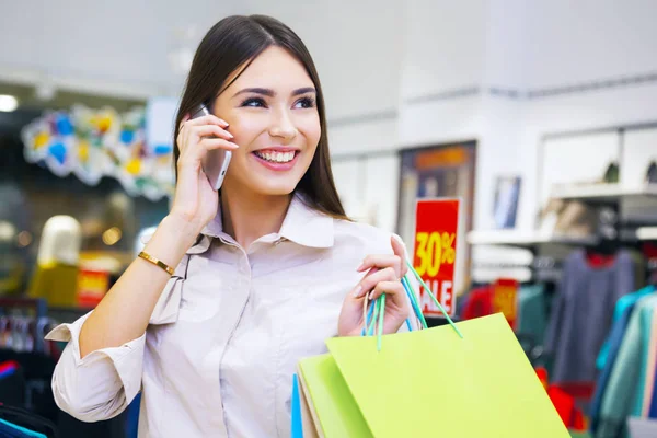 Mulher bonita com sacos de compras falando ao telefone . — Fotografia de Stock