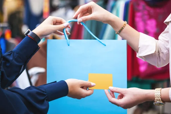 Mãos com saco de compras e cartão de crédito de perto . — Fotografia de Stock