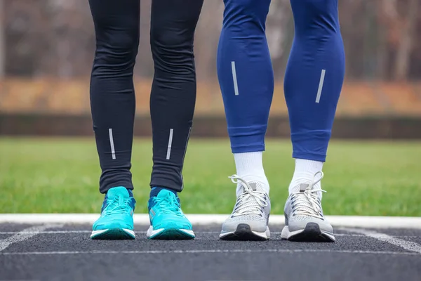 Vista frontal recortada de dos corredores en zapatillas de running . — Foto de Stock