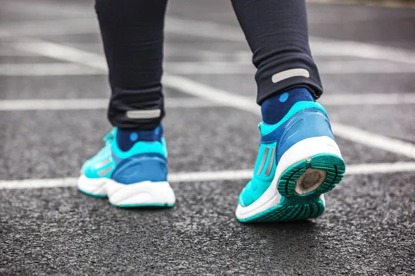 Tiro cortado por trás dos sapatos de corrida de uma mulher . — Fotografia de Stock