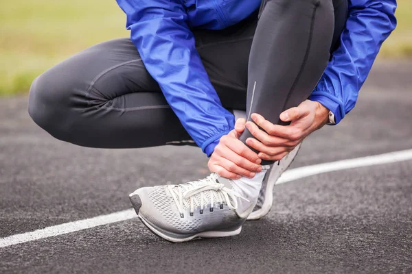 Cropped shot of a young man holding his ankle in pain sprain a f — Stock Photo, Image