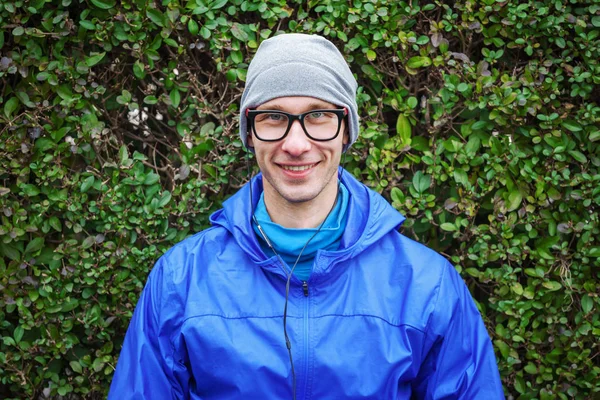 Retrato de cara bonito em roupas esportivas contra arbusto verde . — Fotografia de Stock