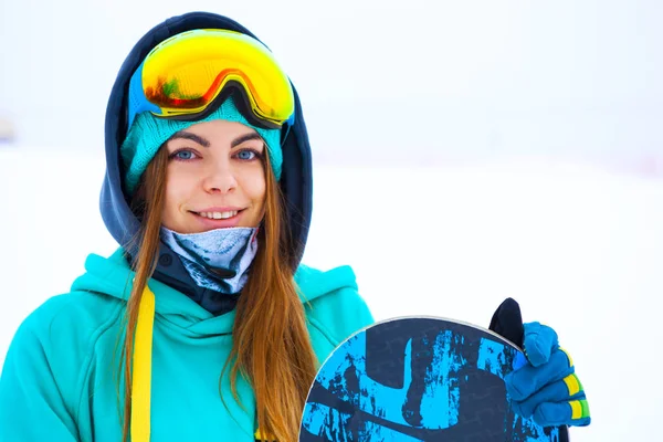 Hermosa joven snowboarder chica sosteniendo snowboard . — Foto de Stock
