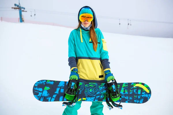 Красивая юная сноубордистка держит сноуборд . — стоковое фото