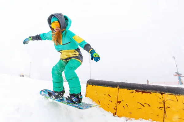 Jeune snowboarder sautant sur la rampe . — Photo