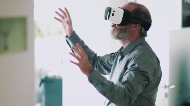 Uomo d'affari maturo che indossa googles realtà virtuale / VR Occhiali con cui lavorare in ufficio moderno — Video Stock