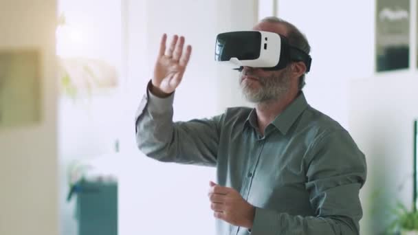 Homem de negócios maduro vestindo óculos de realidade virtual / óculos VR para trabalhar no escritório moderno — Vídeo de Stock