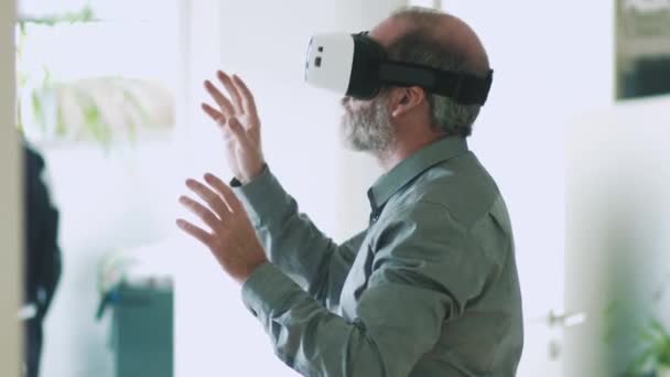 Homem de negócios maduro vestindo óculos de realidade virtual / óculos VR para trabalhar no escritório moderno — Vídeo de Stock