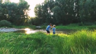 Vahşi doğada bir nehirde oynayan çocuklar