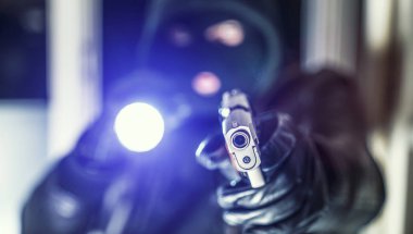 Masked burglar with pistol gun clipart