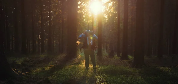 Mladý muž v tichém lese s slunečního záření — Stock fotografie