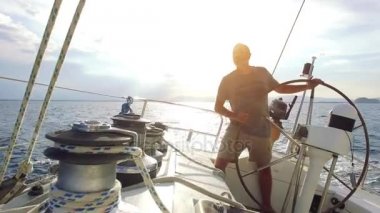 Adam onun yelkenli deniz direksiyon 