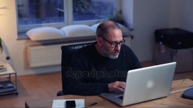 Ofiste dizüstü bilgisayar kullanan iş adamı